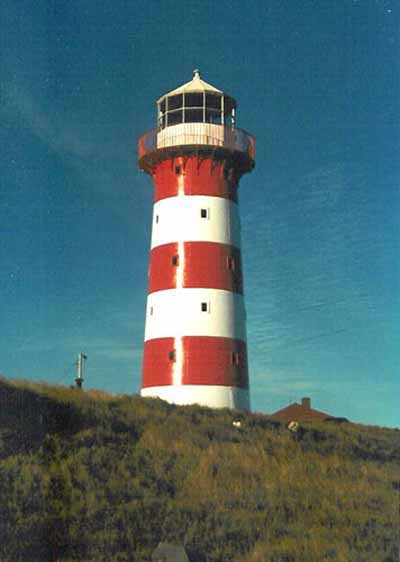 View of the Cape Pine Lighthouse, showing the smooth, painted finish of the exterior walls with its distinguishing colour scheme of alternating white and red, 1990. © Agence Parcs Canada / Parks Canada Agency, 1990.