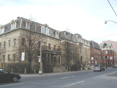 Panoramic view of the Bank of Upper Canada Building (left) demonstrating the organization of the original structure, with seven bays on the façade and four bays along the sides, creating a broad but compact mass compatible with its surroundings, 2003. © Parks Canada Agency / Agence Parcs Canada, 2003.