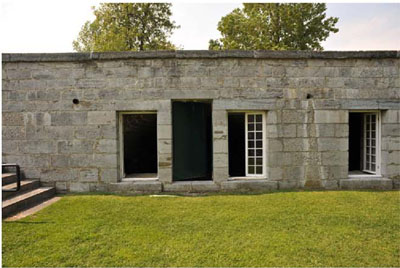 Front facade of the West Front casemates portraying its simple, unadorned stone façade, with a door flanked by two side windows, 2009. © Parks Canada / Parcs Canada, 2009  HRS #