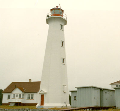 General view of the Light Tower, showing the tall massing, which consists of a white concrete, octagonal tapered tower with a flared cornice that supports a lantern, 2000. © Transport Canada / Transports Canada, 2000.