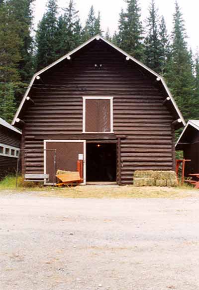 Facade of the Horse Barn at Yoho Ranch depicting the south elevation and demonstrating the simple, symmetrical and well-proportioned composition of this rectangular barn which features a large entrance door, second level hayloft doors, and a gambrel roof, © Cultural Resource Services, Calgary, 1999