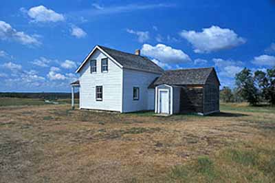 General view of the rear of the Former Jean Caron Sr. House showing the simple, rectangular form and one-and-a-half storey massing of the functional structure, 2003. © Parks Canada Agency / Agence Parcs Canada, D. Venne, 2003.