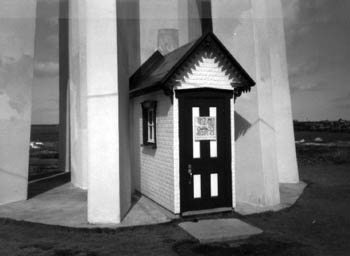 Vue de l'avant du phare, qui montre le portique d’entrée, qui évoque une construction résidentielle, 1990. © Parks Canada Agency / Agence Parcs Canada, 1990.