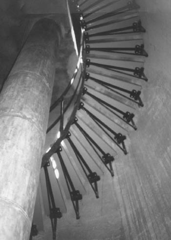 Vue de l'intérieur du phare, qui montre l’escalier en colimaçon, qui mène à chaque niveau et au fanal, 1990. © Parks Canada Agency / Agence Parcs Canada, 1990.