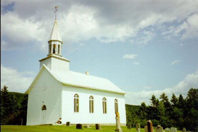 View of St. Peter's Anglican Church, showing its nature park surroundings and the adjacent cemetery, 1992. © Agence Parcs Canada / Parks Canada Agency, André Charbonneau, 1992.