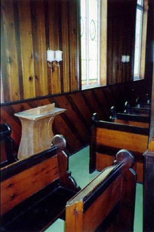 View of the interior of St. Peter's Anglican Church, showing the Victorian varnished wood panelling, 1992. © Agence Parcs Canada / Parks Canada Agency, André Charbonneau, 1992.