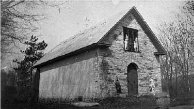 View of the Family Museum, showing the denuded appearance of the exterior, with walls constructed of plain stone and brick  without any openings other than those of the main façade, circa 1915. © Agence Parcs Canada / Parks Canada Agency, vers / circa 1915.
