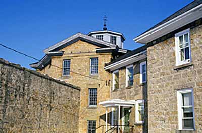 Detail view of the Huron County Gaol, showing the three-storey octagonal central block under a shallow octagonal roof surmounted by a lantern, 1995. © Parks Canada Agency / Agence Parcs Canada, J. Butterill, 1995.