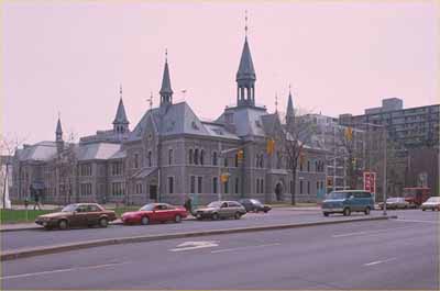 Vue en angle de l'ancien Ottawa Teachers' College montrant la façade avec l'entrée principale donnant sur la rue Elgin et un côté, 1993. (© Parks Canada Agency/ Agence Parcs Canada, 1993.)