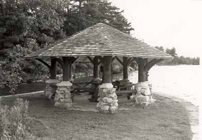 View of the Gazebo of the Batterman's Point Complex, showing the octagonal, shingled roof, rubble-stone piers, and peeled-log posts, 1992. © Parks Canada Agency / Agence Parcs Canada / Historica Resources Ltd., 1992.