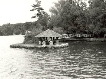 View of the exterior of the Gazebo, showing the picturesque quality as expressed through its small scale, the Rustic style design and use of local materials, 1992. © Parks Canada Agency / Agence Parcs Canada / Historica Resources Ltd., 1992.