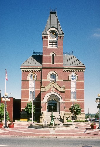 View of the exterior of Fredericton City Hall, showing its Second Empire style, defined by its high hipped roof, central clock tower and projecting entrance portico. © Parks Canada Agency / Agence Parcs Canada.