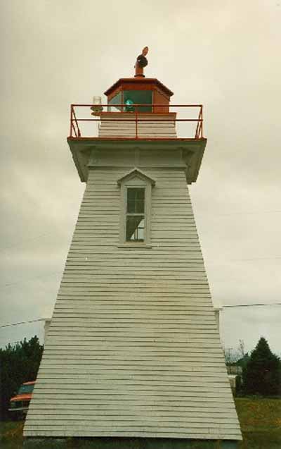Side elevation of the Tower, showing the low, square massing and profile comprised of a tapered shaft with a square wooden gallery and octagonal lantern, 1990. © Canadian Coast Guard / Garde côtière canadienne, 1990.