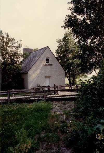 Façade of the French People's House, showing its storey-and-a-half massing, built close to the ground, with few window openings, 1991. © Parks Canada Agency / Agence Parcs Canada, Christine Chartré, 1991.