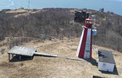 General view of the Partridge Island Light Tower, showing its colour pattern, with each side painted alternately in red or white. (© Canadian Coast Guard / Garde côtière canadienne.)