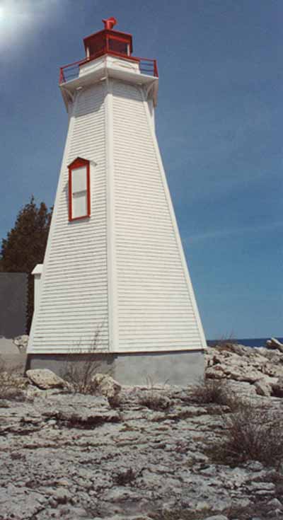 Vue de l'extérieur du phare, qui montre le parement de planchettes de bois étroites peintes en blanc, 1990. © Department of Transport / Ministère des Transports, 1990.