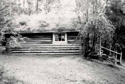 Side view of the Robert Service Cabin, showing the rustic, low-lying form, 1987. © Parks Canada | Parcs Canada, 1987.