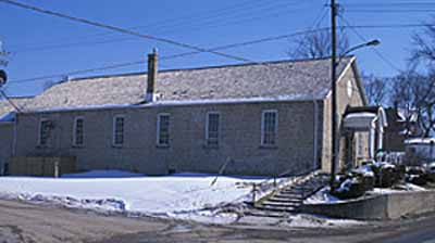 Side view of the Former Elora Drill Shed, showing its regularly placed multi-pane sash windows and stone construction, 1995. © Parks Canada Agency / Agence Parcs Canada, J. Butterill, 1995.
