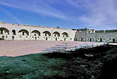 General view of the Fort Henry parade grounds showing the surviving elements of the original fortification, including the design, form and materials of the built and landscaped components, 1995. © Parks Canada Agency/Agence Parcs Canada, J. Butterill, 1995.