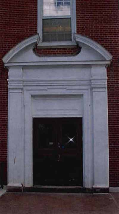 Detail view of the Science Building's main entrance depicting the the use of applied Classical decorative millwork around the entrances, and consisting of pilasters, an entablature and a broken pediment, 2001. © Public Works and Government Services Canada / Travaux publics et Services gouvernementaux Canada, 2001