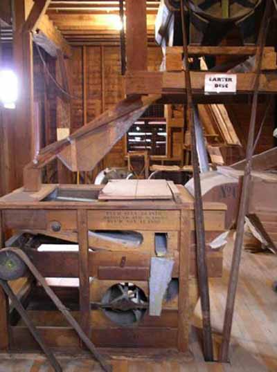 Interior view of the Esterhazy Flour Mill National Historic Site of Canada, showing the carter disc above and fanning mill below, 2007. © Agence Parcs Canada / Parks Canada Agency, A. Roos, 2007.