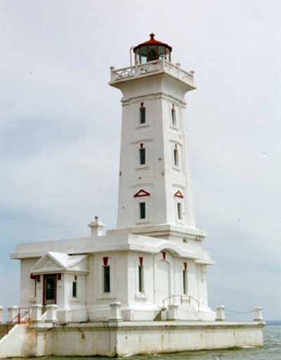 Corner view of Point Abino Light Tower, showing its five-storey tapered, square column rising from a single-storey podium elaborated with classically derived decorative features, 1997. © Parks Canada Agency /Agence Parcs Canada, A. Powter, 1997.