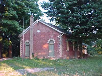 View of the exterior of Former Atha School House, showing the pattern of openings with two doors on the front façade (one for each gender), 2005. © Department of Public Works and Government Services / Ministère des Travaux publics et services gouvernementaux, Don Macdonald, 2005.