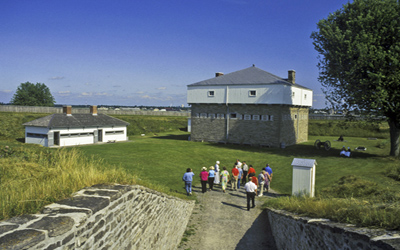 General view of Fort Wellington showing design as three sections including a squat lower storey, an overhanging upper storey, and a pyramidal roof, 2006. © Parks Canada Agency / Agence Parcs Canada, Brian Morin, 2006.