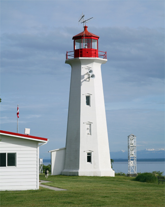 General view showing Cape Mudge Lighthouse showing its two foghorns protruding from an upper-level enclosed window, 2009. (© Kraig Anderson - lighthousefriends.com)