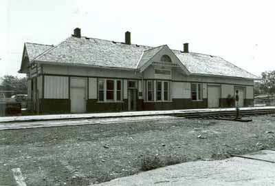 Vue en angle de l'ancienne gare ferroviaire de la Canadien National, montrant la façade arrière et celle du côté, 1992. (© A. M. de Fort-Menares, 1992.)