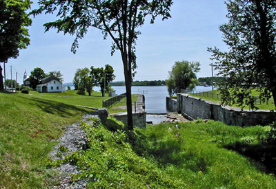 General view of Carillon Canal, showing the relationship between the superintendent’s residence, the old house of the toll collector, the entry to the first canal and lock number one of the second canal, 2003. © Parks Canada Agency / Agence Parcs Canada.