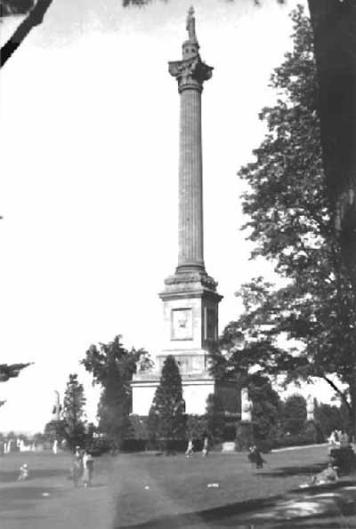 View of Brock's Monument, showing the monument’s tall, elegant form and geometric massing which consists of a tall circular column on a square base, ca. 1920. © Archives of Ontario| Archives publiques de l'Ontario, ca./vers 1920.