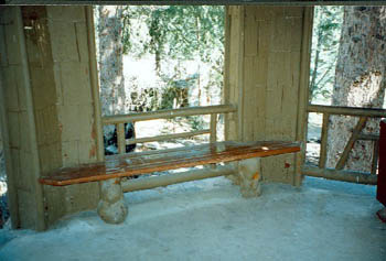 Interior view of Devonian Pavilion, showing the flag stone floor and the burl specimens utilized for the tie beams and bench legs, 1997. © Agence Parcs Canada / Parks Canada Agency, 1997.