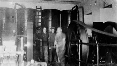 View of the interior of the Searchlight Engine Room demonstrating the remaining interior fittings with two original Hornsby-Ackroyd engines and dynamos, ca. 1930. © Fort Rodd Hill Photo Collection / Collection de photos Rodd Hill, ca. 1930