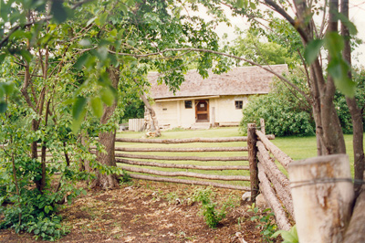 The Negrych house as seen from the fenced orchard/garden. © Parks Canada Agency / Agence Parcs Canada, J. Mattie, 1996.