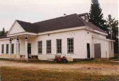 General view of the Main Hatchery Building, showing the horizontal wood siding of the exterior walls and the black and white exterior trim, 1993. © Parks Canada Agency / Agence Parcs Canada, 1993