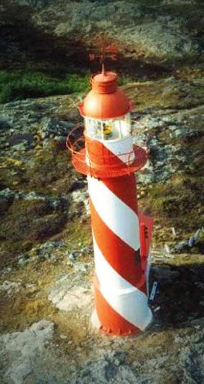 General view of the Bacalhao Island Lighttower showing the spiraling daymark colours extending up into the lantern’s murette. © Department of Fisheries & Oceans Canada/Département de pêches et océans Canada