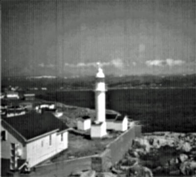 General view of the Channel Head Lighttower, showing the smooth tubular construction and overall utilitarian appearance of the structure in its setting among the only structures on a small island, 1987. © Canadian Coast Guard/Garde côtière canadienne, 1987.
