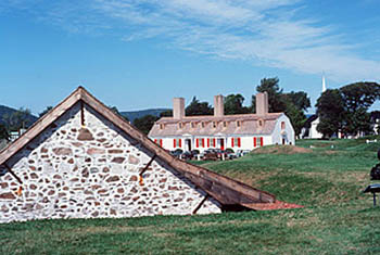General view of the Fort Anne National Historic Site of Canada showing some surviving remnants of the original fort such as the Powder Magazine (left) and the Officer's Quarters (right), 1977. © Parks Canada Agency / Agence Parcs Canada, T. Grant, 1977.