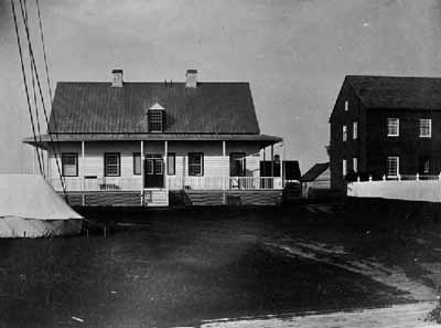 Historical image of Moose Factory, showing part of the Staff House on the right, 1868. © Library and Archives Canada / Bibliothèque et Archives Canada, James L. Cotter, C-001719.