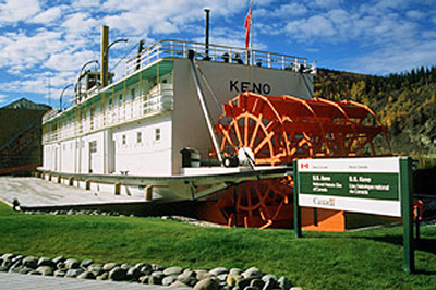 General view of the rear of the S.S. Keno showing the paddle wheels ensuring the completeness of its hull, superstructure, propulsion and auxiliary systems, 2002. © Parks Canada Agency / Agence Parcs Canada, J. Armitage, 2002.