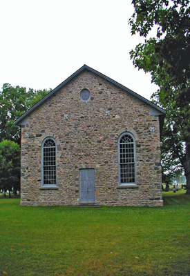 General view of Old Stone Church, showing its end-gable entrance with a central door flanked by two large multi-pane windows, 2006. © Parks Canada Agency / Agence Parcs Canada.