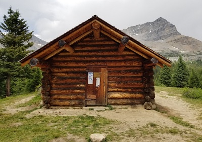 Front facade of the Halfway Hut showing the deep overhang above the cabin entrance. © Parks Canada / Parcs Canada, n.d.