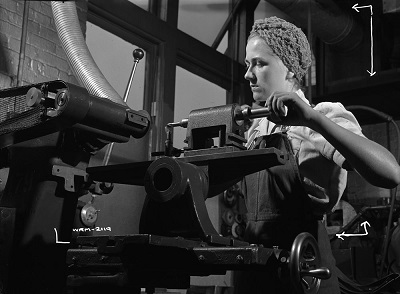 Woman tool grinder adjusts a machine manufacturing bomb throwers at the Canadian Elevator Equipment Co. © National Film Board of Canada | Office national du film du Canada. Photothèque / Library and Archives Canada | Bibliothèque et Archives Canada