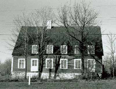 View of the Pagé - Rinfret House / Beaudry House, showing the placement of chimneys and dormers within the slope of the roof, 1969. © Parks Canada Agency / Agence Parcs Canada, 1969.