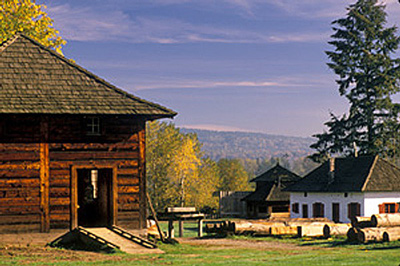 General view of the Fort Langley National Historic Site of Canada showing viewplanes from the palisades to the Fraser River and McMillan Island, to the east, looking upriver towards the site of the earlier fort, and to the countryside and west, 1988. © Parks Canada Agency / Agence Parcs Canada, A. Cornellier, 1988.