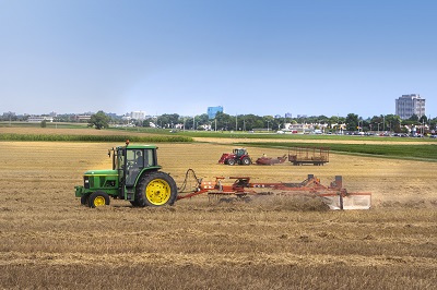 Tracteurs et râteaux dans un champ après la récolte © Agriculture and Agri-Food Canada | Agriculture et Agroalimentaire Canada