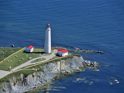 General view of Cap-des-Rosiers lighthouse, showing its rugged, exposed site atop high cliffs on a point of land separating two major bodies of water. (© Parks Canada Agency / Agence Parcs Canada.)