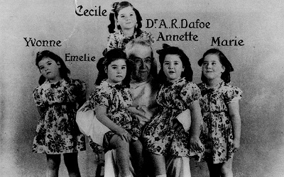 The Dionne Quintuplets, Yvonne, Emelie, Cecile, Annette and Marie, with Dr. Allan Roy Dafoe who delivered them. © N.E.A. Service Inc. / Library and Archives Canada | Bibliothèque et Archives Canada /PA-026034