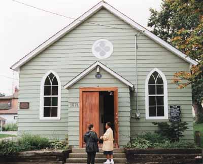 Vue de la façade principale de l’église British Methodist Episcopal R. Nathaniel Dett, qui montre sa construction à charpente en bois et le petit porche d’entrée. (© Parks Canada Agency / Agence Parcs Canada.)